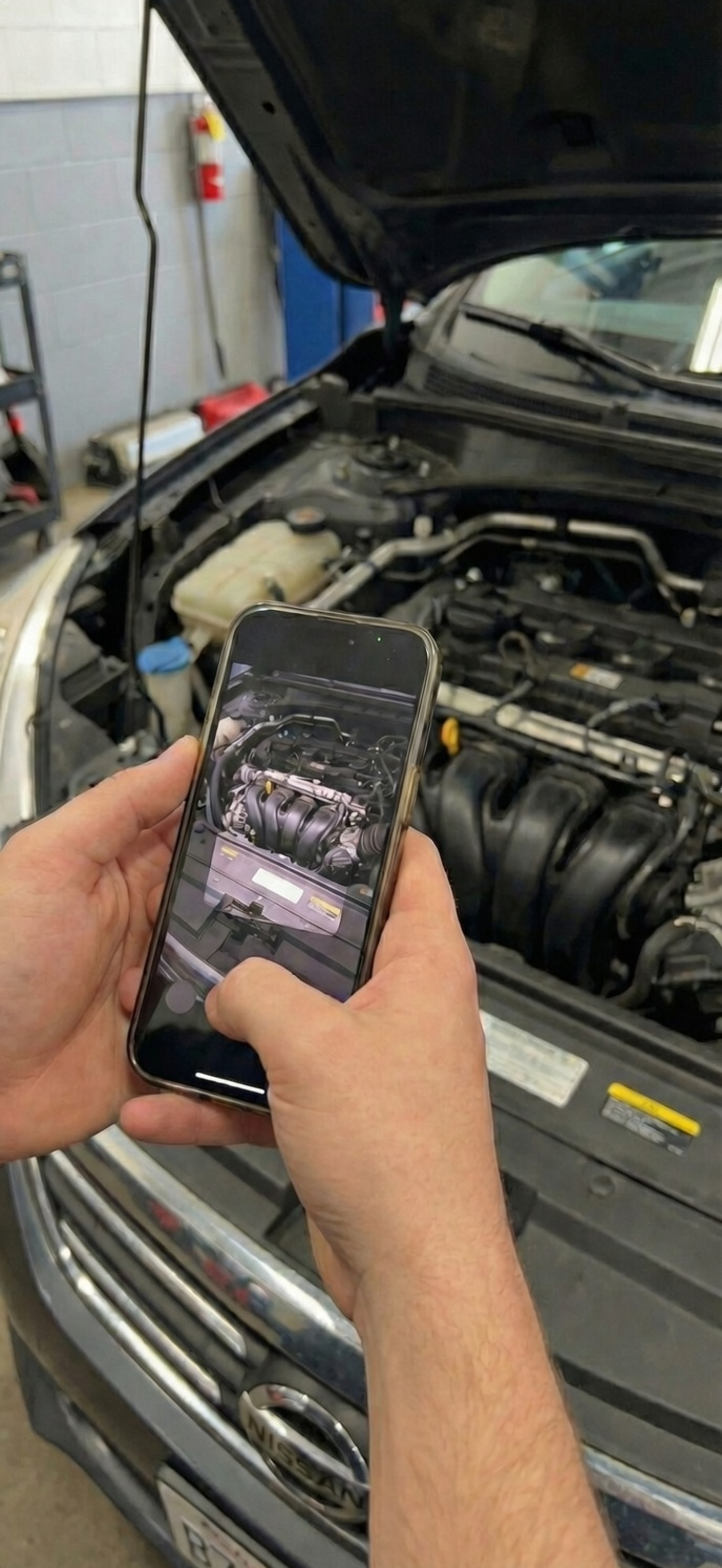 Person using CarSight to scan under the hood of a car engine